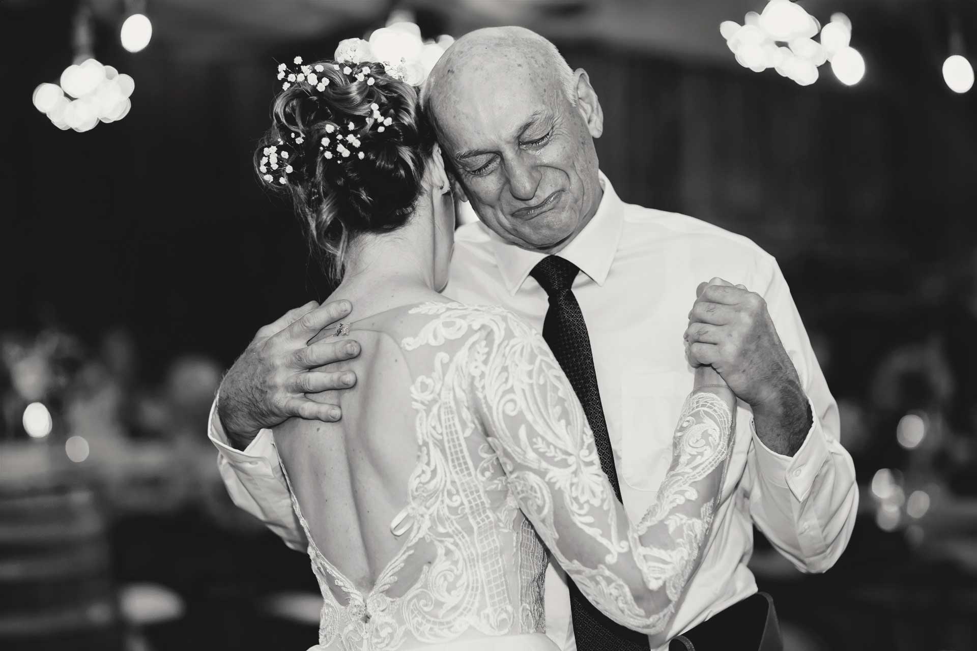 An emotional father fights back tears during the father/daughter dance. Candid documentary photography emphasizes these special heartfelt moment.s