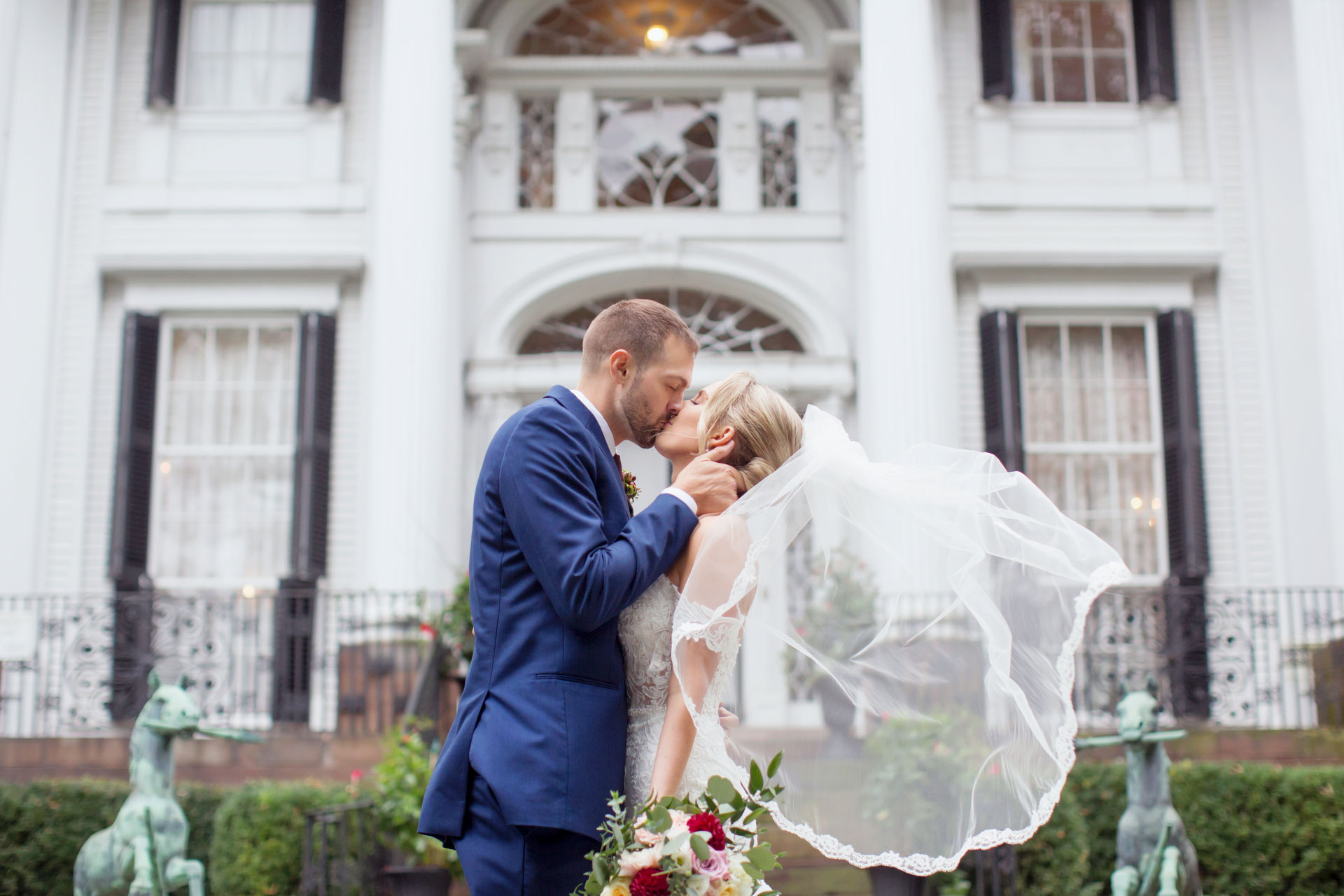 A bride and groom kissing in front of the misselwood estate.