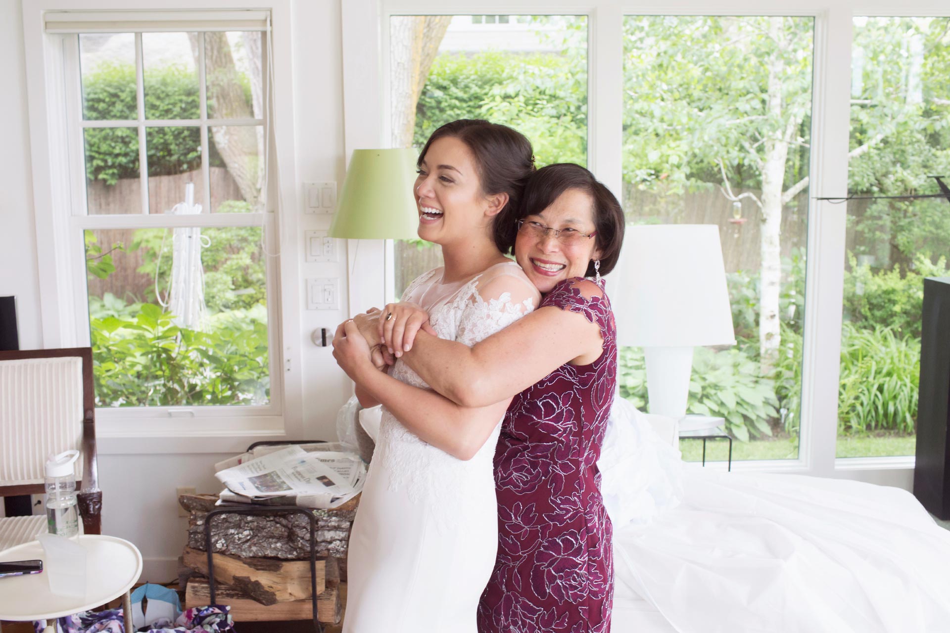 A bride's mom gives her a big hug after she puts her wedding dress on.