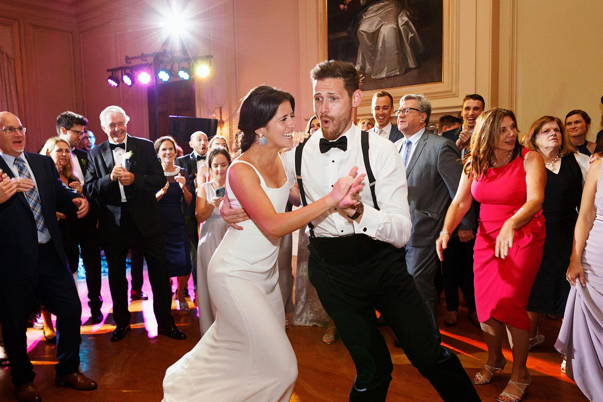 A fun couple surrounded by guests dancing on their wedding.