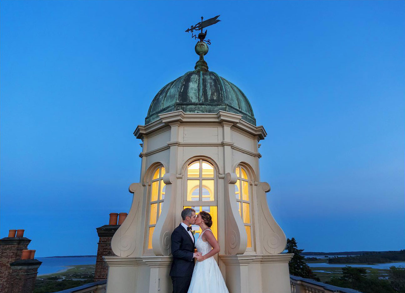 A bride and groom kissing at dusk on top of the Crane Estate at Castle Hill in Ipswich, MA. 